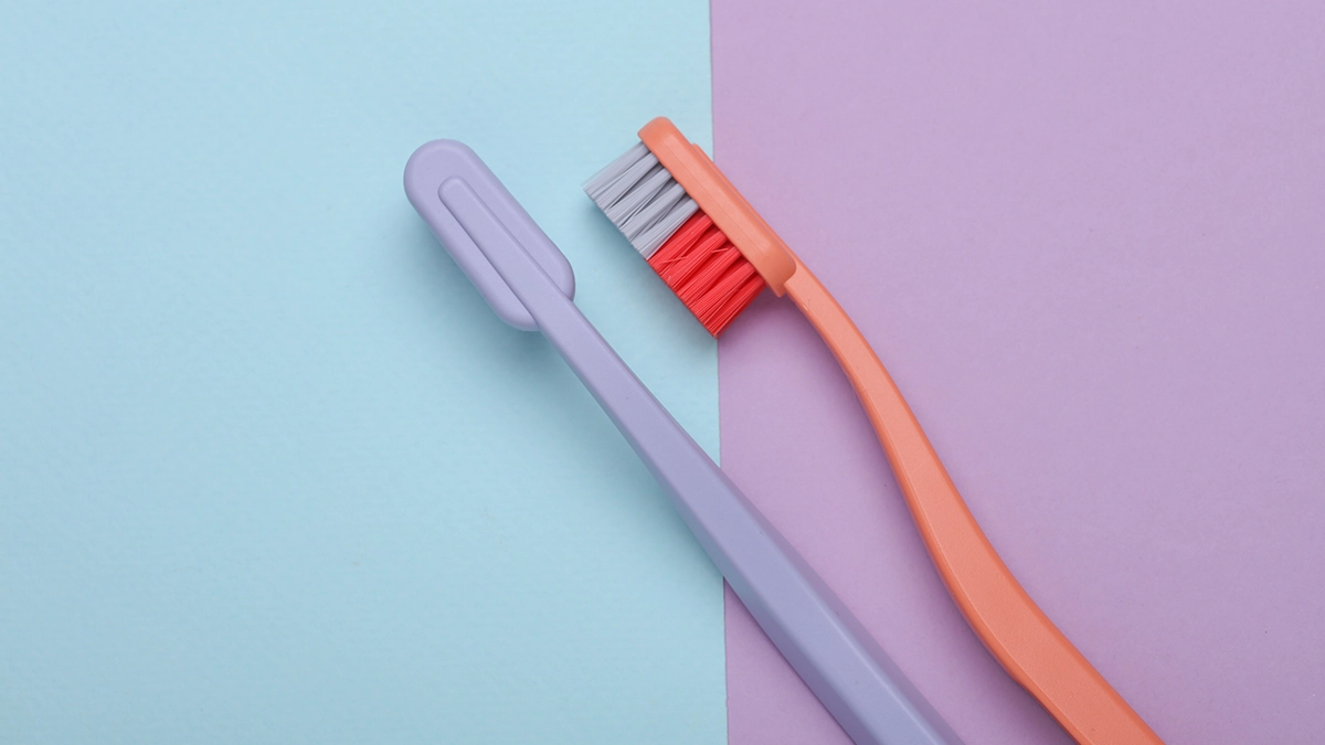 a pair of toothbrushes on a purple and blue background